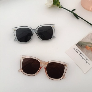 Détail de lunettes de soleil carrées oversize avec rivets en étoile sur monture transparente