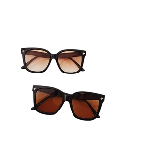 Lunettes de soleil carrées oversize avec monture noire, verres bruns et rivets en étoile
