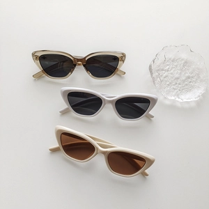Close-up of retro cat eye sunglasses in transparent brown, white and beige colors