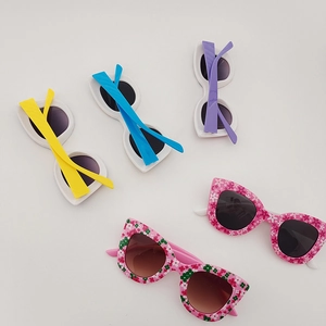 Five pairs of kids cat-eye sunglasses in solid colors and floral patterns with UV protection