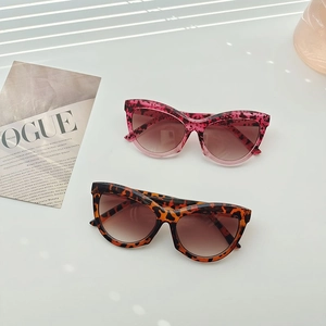 Chic leopard print triangle sunglasses styled on a magazine with artistic shadows