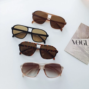 Retro double-bridge aviator sunglasses in various colors displayed with a fashion magazine