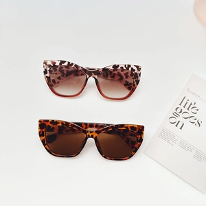 Lunettes de soleil œil-de-chat vintage motifs léopard et écaille sur fond blanc épuré