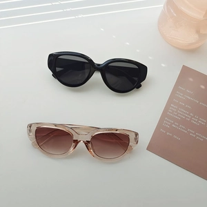 Futuristic sporty sunglasses with thick cat-eye frames in black and champagne color