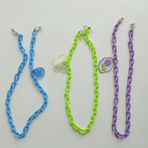 Gros plan de chaînes à lunettes en acrylique coloré avec pendentifs sourire et papillon
