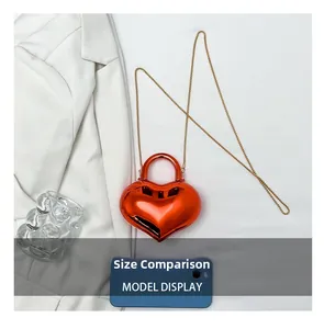 Size comparison of a red heart-shaped glossy acrylic mini bag with a gold chain