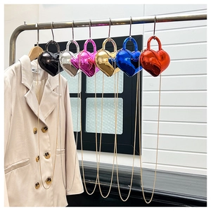 Close-up of heart-shaped mini handbags in metallic finishes hanging on a display rack
