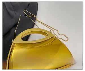 Detail der gold gespiegelten Clutch mit D-Griff und schlanker Schlangenkette