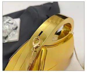 Detailansicht der goldenen Acryl-Abendtasche mit Spiegelglanz und feiner Gliederkette