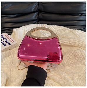 Nahaufnahme der pinken Acryl-Clutch mit goldenem Griff und eleganter Metallkette