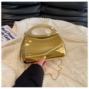 Nahaufnahme der goldenen Acryl-Box-Tasche mit glänzender Oberfläche und Metallkette