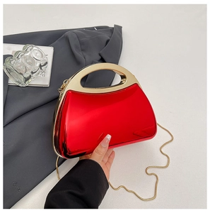 Detail der roten Abendtasche mit Metallic-Finish, Goldgriff und abnehmbarer Kette