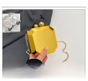 Detail of gold geometric evening clutch with mirror finish and octagonal gem-cut design