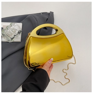 Nahaufnahme der goldenen Acryl-Box-Tasche mit Spiegeleffekt und integriertem Griff