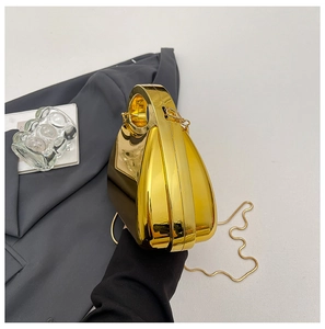 Detail einer goldenen Abendtasche in Wassertropfenform mit Metall-Finish und Rundgriff