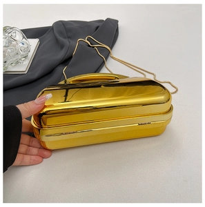 Detail of glossy gold mirror surface acrylic evening box bag with metal handle and chain
