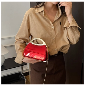 Detailansicht der roten Acryl-Box-Clutch mit goldenem Griff und elegantem Kettengurt