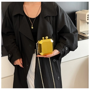 Close-up of golden mirror geometric chain bag with spherical clasp and metallic chain
