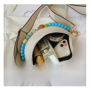 Interior view of off-white crossbody bag showing capacity for phone and cosmetics