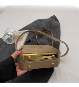 Detail of khaki leather box bag showing polished gold mirror finish and HEA letter embossing