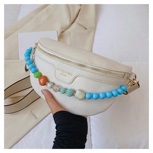 Detail of off-white lychee leather chest bag with colorful bead chain and gold zipper