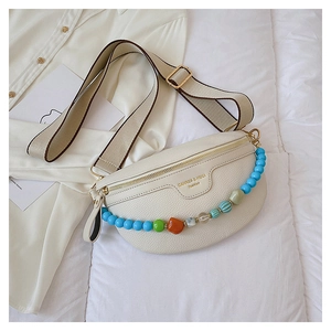Detail of off-white crescent waist bag with colorful beaded chain and canvas strap