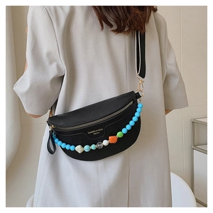 Close-up of black crescent crossbody bag with colorful beads and striped fabric strap