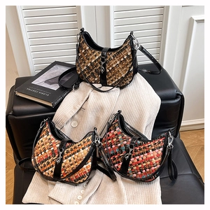 Detailed view of woven hobo bags in various colors on a leather sofa with natural lighting