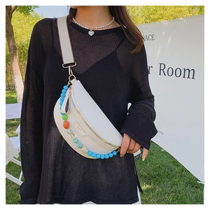 Detail of white moon chest bag with colorful bead strap and golden zipper on leather