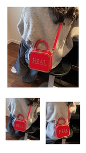 Detailed view of a red octagonal box bag with gold HEAL letters and top handle