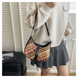 Detailed view of woven handbag with colorful patterns and leather shoulder strap