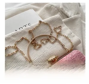 Close-up of pink lace evening bag with sequins, gold frame, and large pearl clasp detail