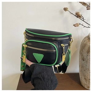 Détail du sac ceinture en cuir noir avec bordure vert fluo et garnitures dorées