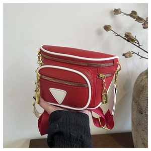 Détail du sac banane en cuir PU rouge avec zips dorés et passepoils blancs contrastés