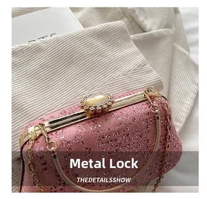 Close-up of pink lace evening bag featuring a gold rhinestone clasp and cat-eye stone