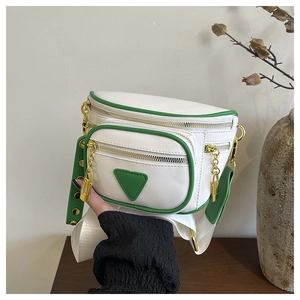 Détail du sac de taille à poches multiples avec accents verts et fermetures éclair dorées