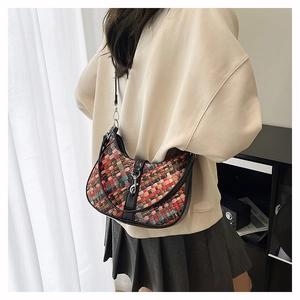Detail of colorful checkerboard woven handbag with black leather trim and metal buckle