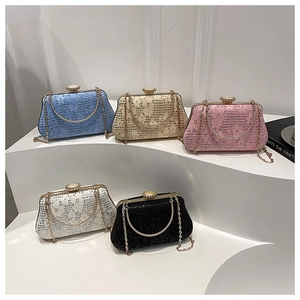 Macro detail of various lace clutch bags featuring pearl clasps and golden metal chains