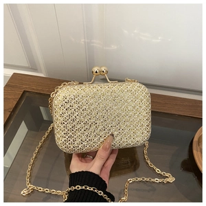 Primo piano della pochette da sera con paillettes dorate e chiusura sferica in metallo
