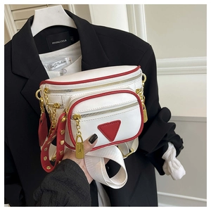 Détail d'un sac banane blanc avec bords contrastés rouges et pendentif cadenas doré