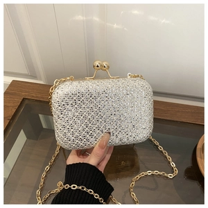 Dettaglio della pochette glitterata argento con chiusura sferica oro e tracolla a catena