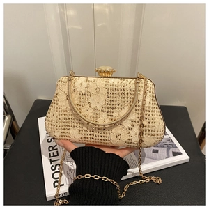 Close-up of floral lace evening clutch with gold metal frame and jewel clasp detail