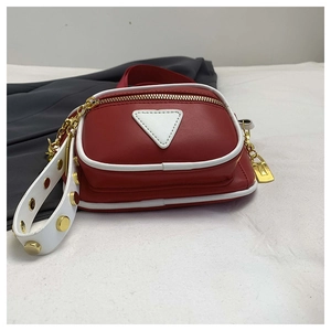Détail du sac bandoulière rouge en PU avec liseré blanc et décor triangulaire en métal