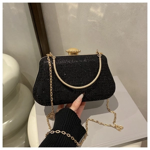 Detail of black lace evening clutch bag with gold chain and gem-inlaid metal clasp