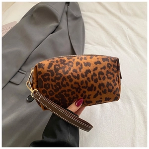 Gedetailleerde weergave van luipaard make-up tas met suède textuur en gouden rits
