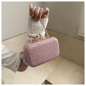 Dettaglio della trama di una pochette da sera rosa con paillettes e fibbia d'oro