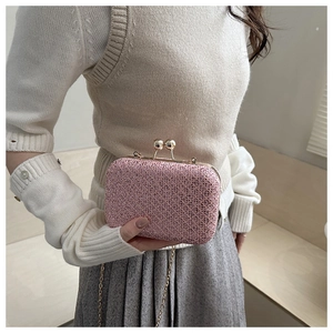 Dettaglio della pochette rosa chiaro con trama a rete intrecciata e chiusura a sfera dorata