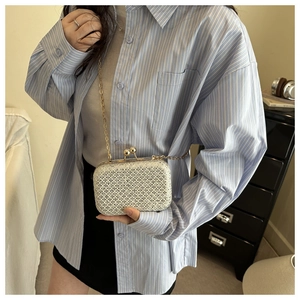 Dettaglio della borsa clutch argento glitterata con catena dorata e chiusura retrò