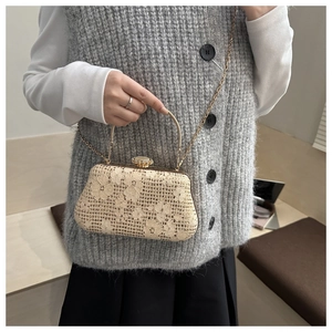 Detail of elegant beige lace evening bag with floral embroidery and golden metal clasp