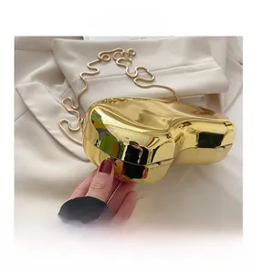 Detail shot of heart-shaped gold mirror box clutch with sleek snake chain and smooth metallic finish